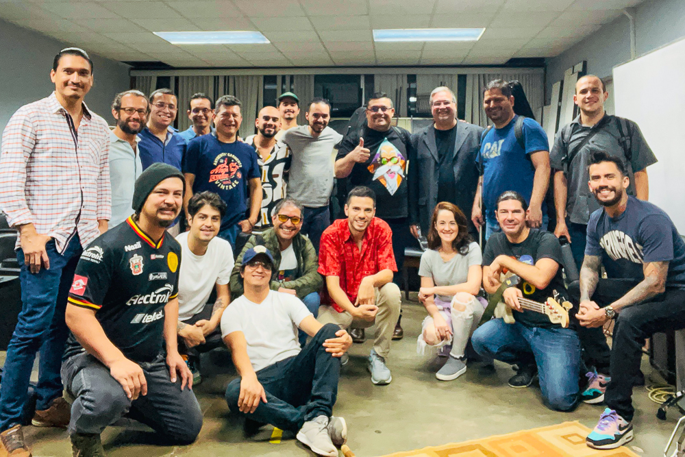 19 adults, all of whom are students and faculty of a jazz workshop at Universidad Nacional, pose for a group photo.