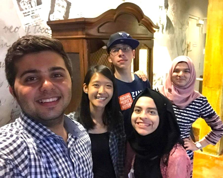 Two boys and two girls surrounded World Learning’s Jenn Chen, director of virtual programming, for a selfie photo. Behind them is a large piece of wooden furniture.
