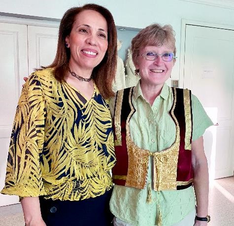 A photo of two women standing side by side and smiling together.