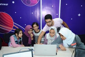 Five students and an instructor work around a laptop