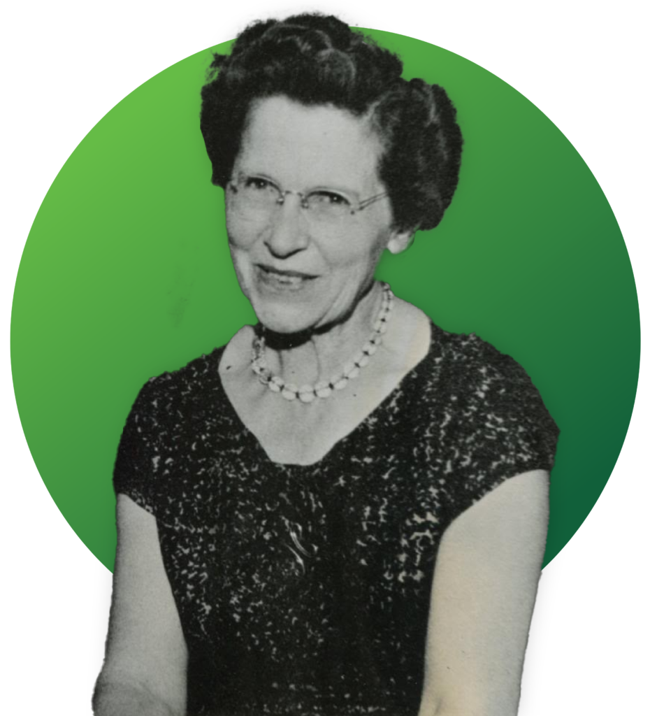 A black and white photo of an older woman smiling for the camera.